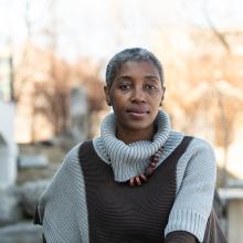 femme noire d'âge moyen à l'extérieur d'un immeuble